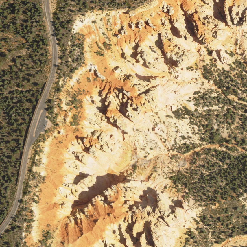 North-up aerial crop of the Agua Canyon study area, with the road at left and exposed rock and forest to the right.